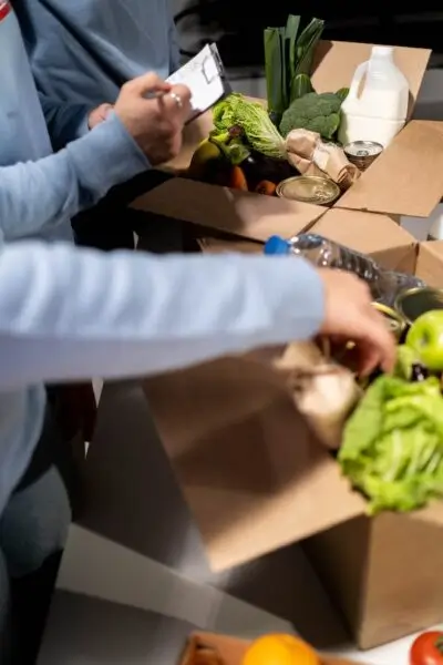 People Packing groceries and food items in to cardboard boxes